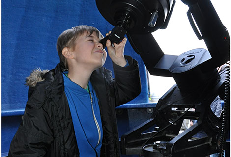 Young boy looking through telescope